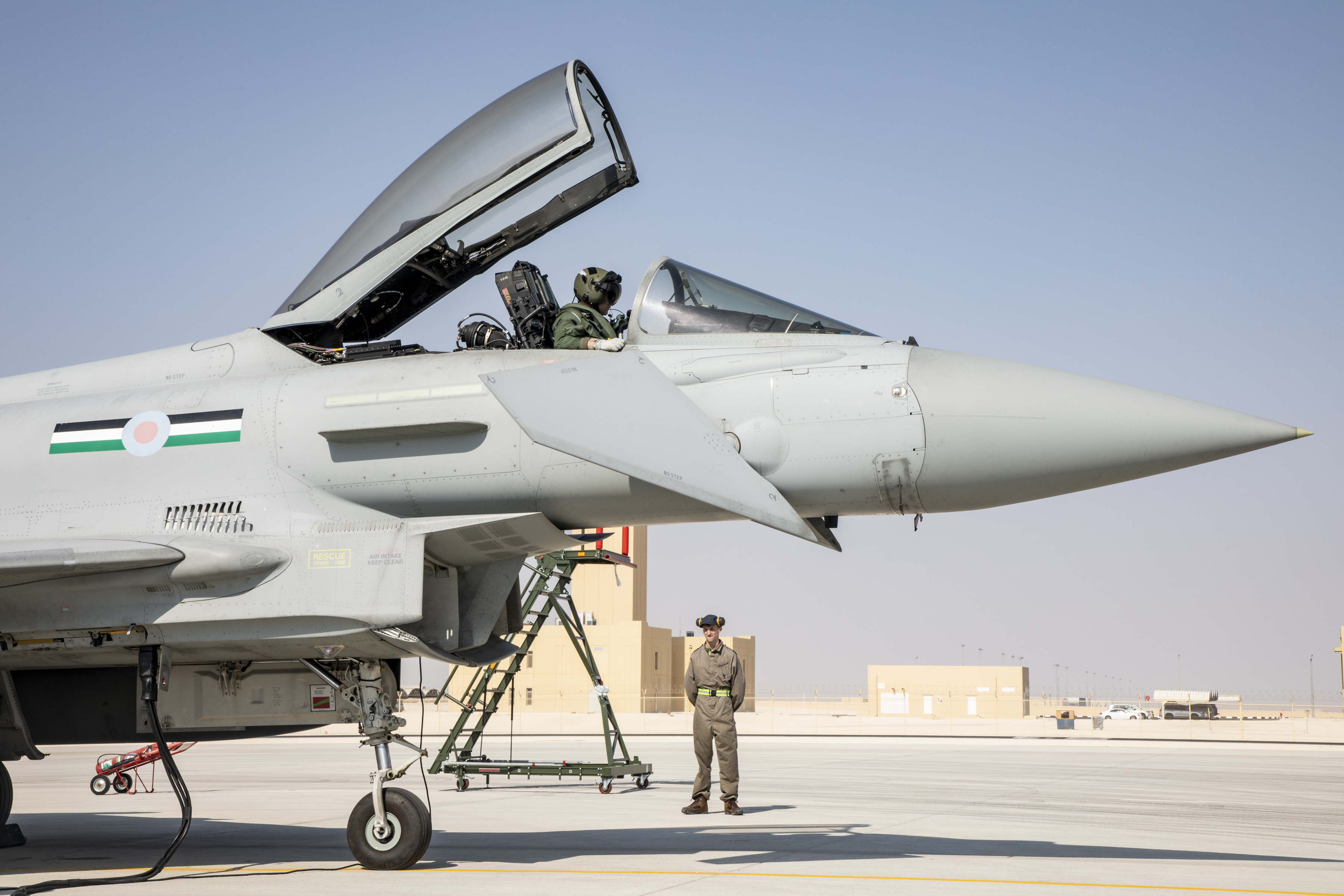 Image shows a pilot in the open cockpit of a Typhoon aircraft on the airfield in Qatar.